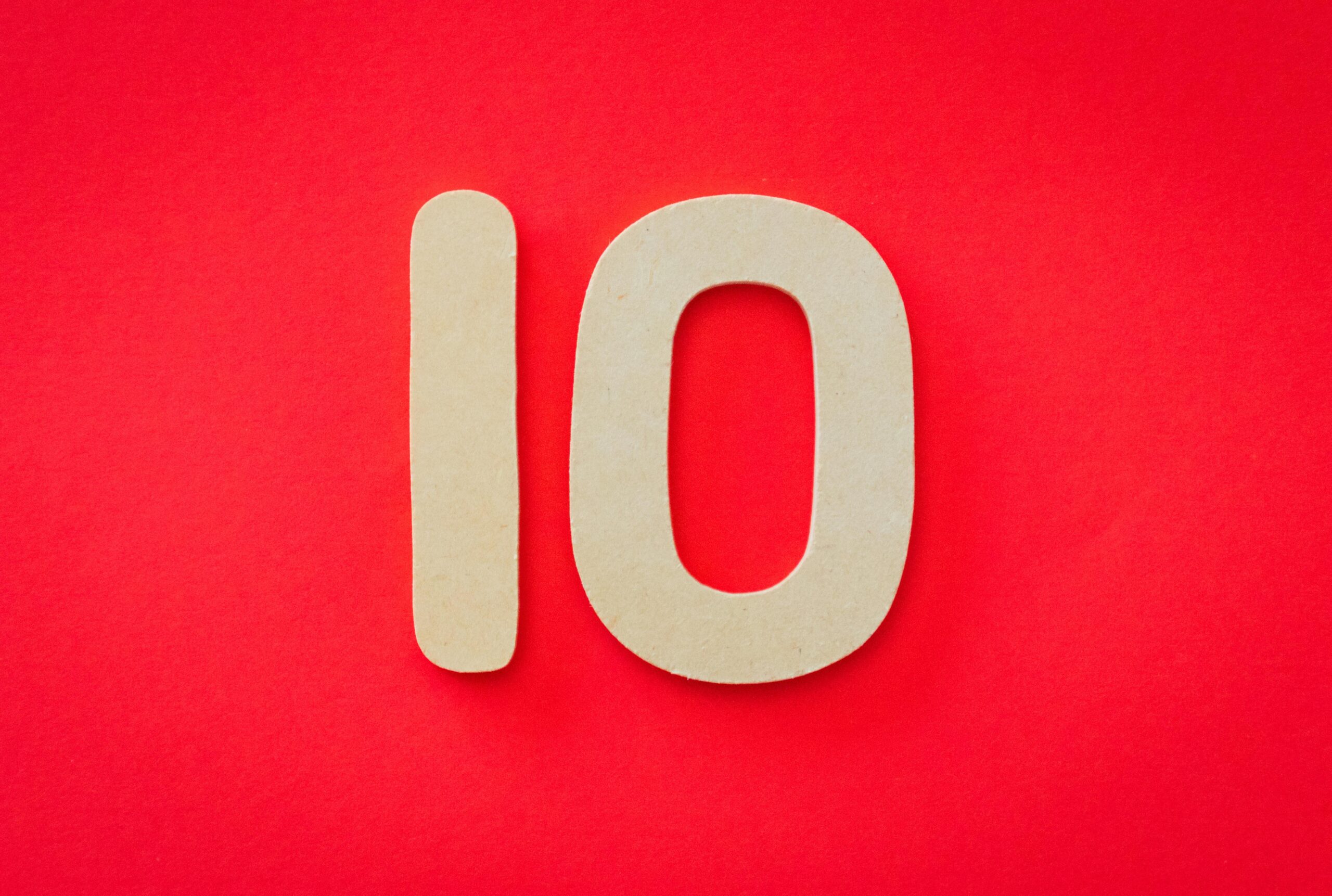 Wooden number 10 on a vibrant red background, ideal for educational and creative projects.